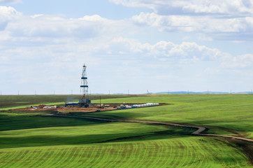 Drilling rig among agricultural fields. View from above