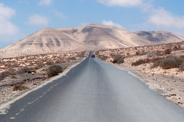 Fuerteventura, Isole Canarie: le montagne del Morro Jable e la strada sterrata per la spiaggia di Sotavento, una delle più famose dell'isola per il windsurf e il kitesurf, il 30 agosto 2016