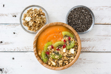 Smoothie with fruit,cereals and chia on white wooden table

