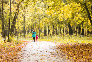 Fototapeta premium Happy mother and child daughter holding hands together in summer or autumn day.