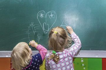 little girl draw on the blackboard, chalk