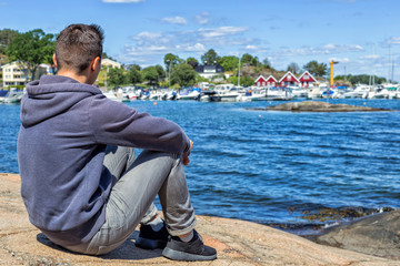 Young man lon the stone near the sea