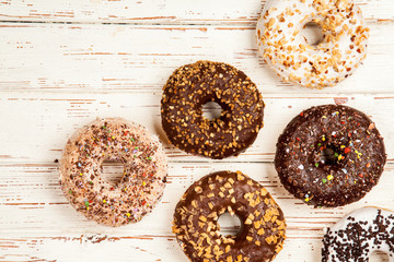 Tasty donuts on white wood background