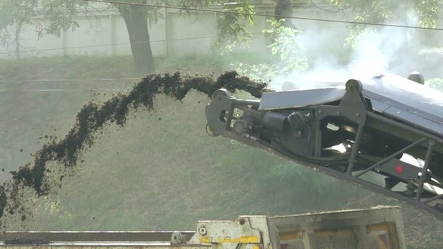 Cold milling machine, milled asphalt falls into the back of the truck, super slow motion