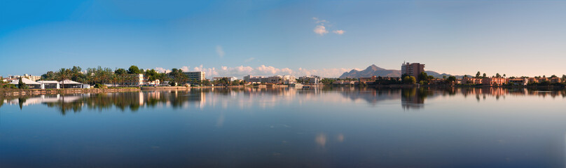 Fototapeta na wymiar hotels is reflected in the Esperanza lake in Port d'Alcudia. Beautiful reflection of the sky and clouds. Alcudia, Mallorca, Spain.