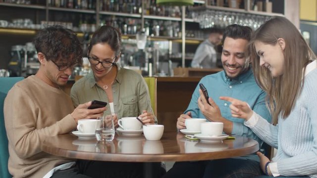 Group of Young Mixed race People using Phones in Coffee Shop. Shot on RED Cinema Camera in 4K (UHD).