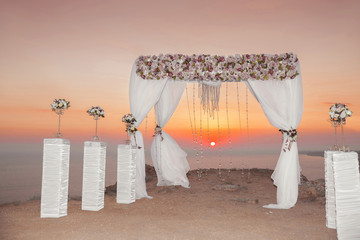 Sunset. Wedding ceremony arch with flowers decorative arrangemen