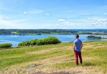 Happy summer vacation for man on green meadow near sea