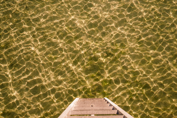 Stegleiter zum Wasser am Bodensee. Wasseroberfläche gekräuselt, Goldfarben 