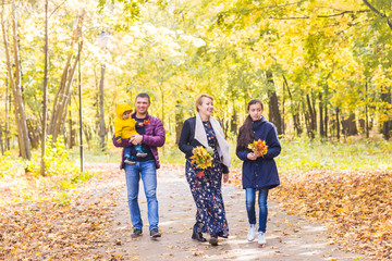 Naklejka premium friendly family walking in the park in autumn together