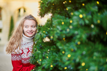 Young woman on a street of Paris decorated for Christmas