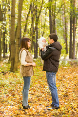 Naklejka premium Portrait of happy young couple with baby son in autumn park