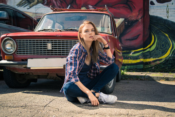 Young attractive model is sitting near the retro car
