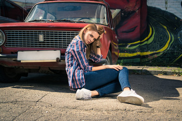 Young attractive model is sitting near the retro car