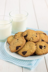 Homemade cookies with chocolate pieces and milk.