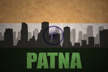 abstract silhouette of the city with text Patna at the vintage indian flag background