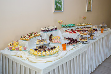 Dessert table for a party. Ombre cake, cupcakes. Candy bar