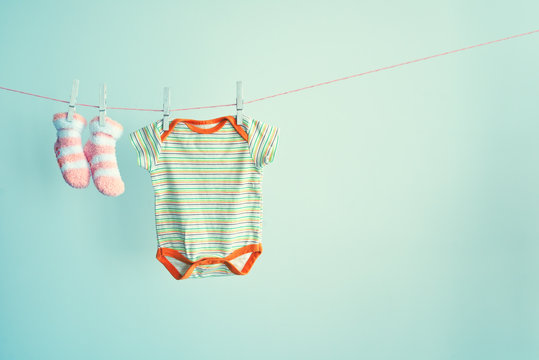 Baby socks and clothes hanging on the clothesline. Background with baby goods with copy space.