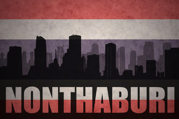 abstract silhouette of the city with text Nonthaburi at the vintage thailand flag background