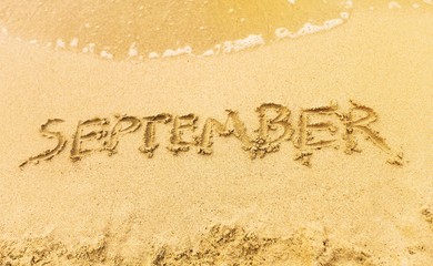 Inscription on wet sand september
beach.