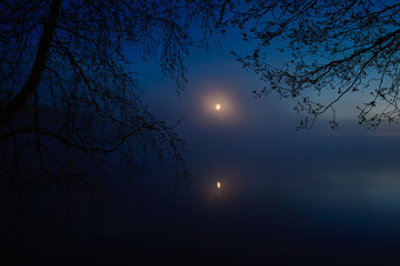 moon in the fog over the lake