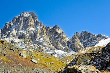 Caucasus Mountains, village Juta. green hill, blue sky, mountain from stones and snowy peak Chaukhebi in summer. 