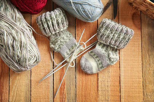 Knitting wool and knitting needles on wooden table