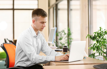 Young man working on laptop in office