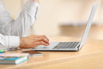 Man typing on laptop in office, closeup