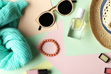 Set of decorative cosmetics and female accessories on color background