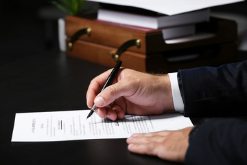 Man signing last will and testament, closeup