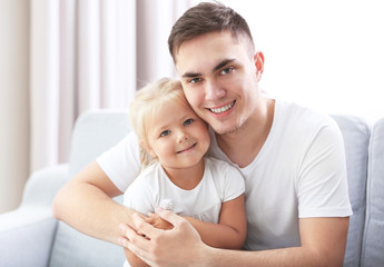 Happy father with daughter on couch