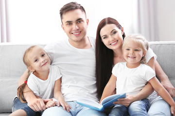 Obraz premium Happy parents with daughters reading book