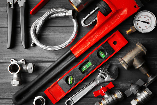 Plumber tools on a gray wooden background