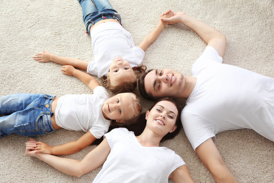 Happy parents with children lying on floor