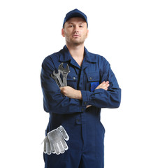 Young mechanic in uniform with a wrench and gloves in pocket, isolated on white