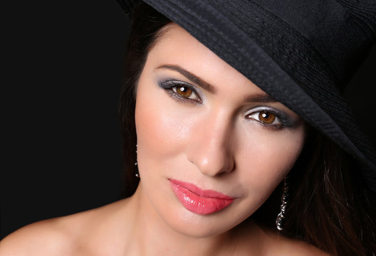 Portrait of young woman with beautiful makeup on black background