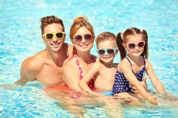 Obraz na płótnie Canvas Happy family in swimming pool at water park