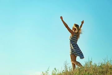 Obraz na płótnie Canvas Happy young woman on blue sky background