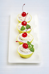 Cupcakes with whipped cream and cherry