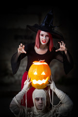 Witch using spells to invoke the Halloween spirits. She is performing her magic with Mummy and Jack O Lantern