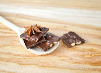 Delicious close-up of chopped chocolate on the wooden spoon
