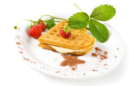 Plate of belgian waffles with fresh strawberries and whipped cream