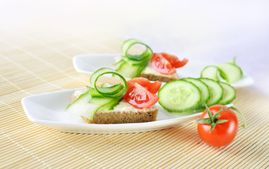 Canapes with butter, cucumber and tomatoes