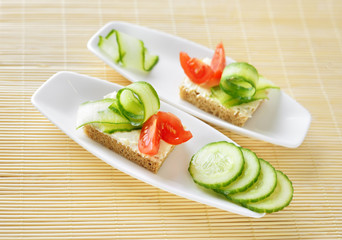 Canapes with butter and vegetables on plate