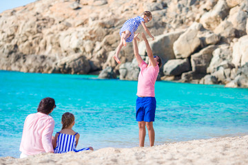 Fototapeta na wymiar Young family having fun on the beach