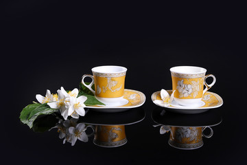yellow cups on black with jasmine flower