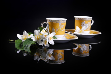 yellow cups on black with jasmine flower