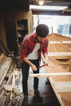 Man preparing wooden boat frame