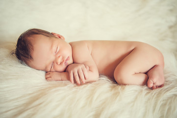 Obraz na płótnie Canvas Sleeping newborn baby on a blanket